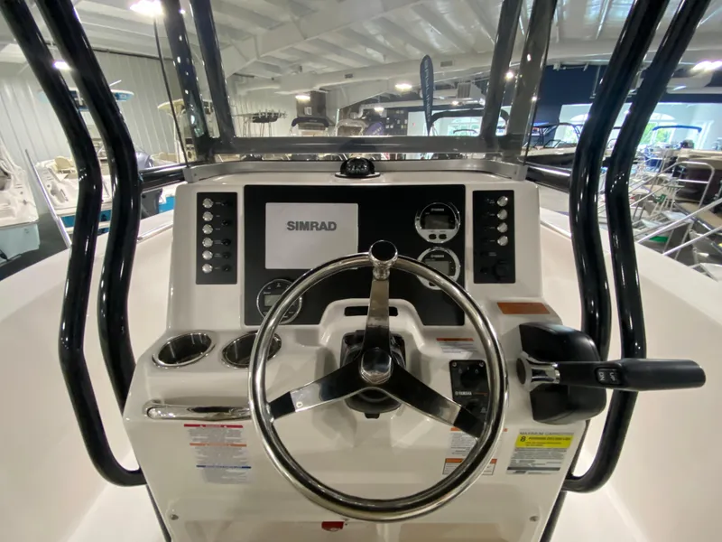 Slide: The Image of 2024 Robalo 202 EXPLORER boat dashboard with Simrad display and steering wheel. - 10
