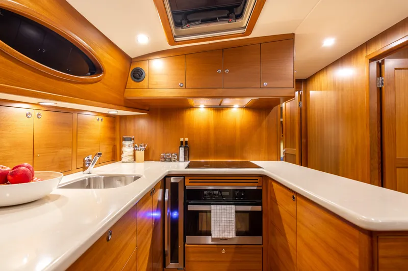 Slide: The Image of Luxurious kitchen interior of 2021 Palm Beach Motor Yachts PB65, featuring wood cabinetry and modern appliances. - 19