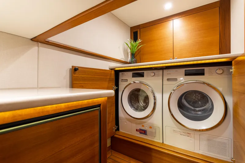 Slide: The Image of Laundry area in 2021 Palm Beach Motor Yachts PB65, featuring modern washer and dryer. - 28