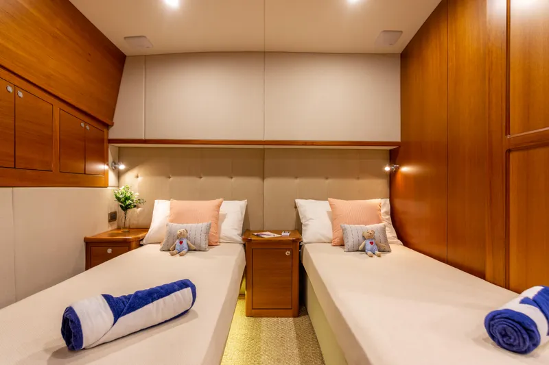 Slide: The Image of Luxurious twin cabin in 2021 Palm Beach Motor Yachts PB65, featuring elegant wood finishes. - 5
