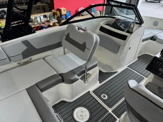 Slide: The Image of 2024 Bayliner VR5 boat interior with gray and white seating and black flooring. - 5