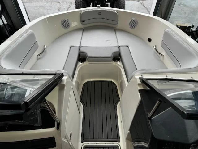 Slide: The Image of 2024 Bayliner VR5 boat interior with cushioned seating and black flooring. - 6