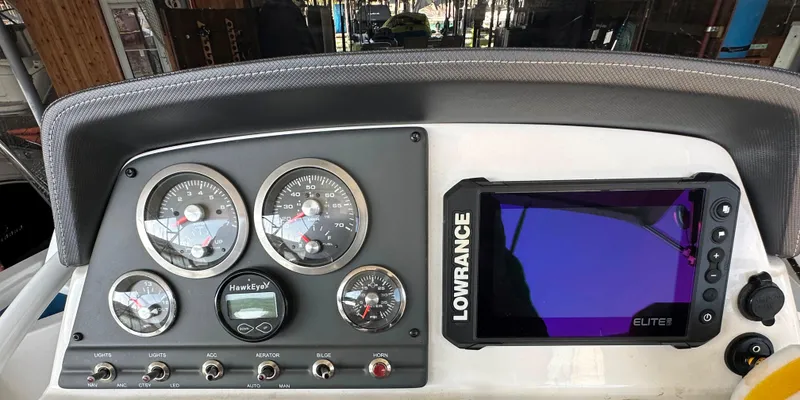 Slide: The Image of 2022 Tahoe 2150 CC boat dashboard with Lowrance Elite fishfinder and analog gauges. - 11