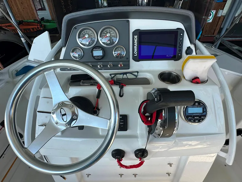 Slide: The Image of 2022 Tahoe 2150 CC boat dashboard with steering wheel, gauges, and Lowrance display. - 12