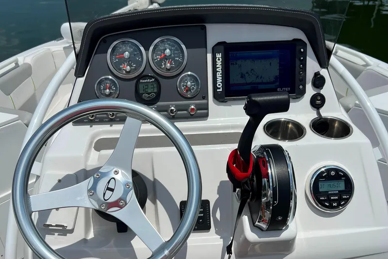 Slide: The Image of 2022 Tahoe 2150 CC boat dashboard with steering wheel, gauges, and Lowrance Elite fishfinder. - 13