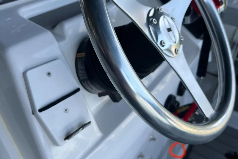 Slide: The Image of Close-up of the steering wheel on a 2022 Tahoe 2150 CC boat. - 15