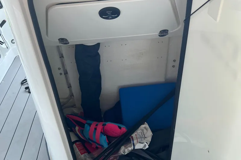 Slide: The Image of Storage compartment of a 2022 Tahoe 2150 CC boat with various items inside. - 27