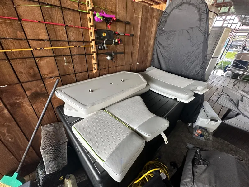 Slide: The Image of 2022 Tahoe 2150 CC boat seats and fishing gear in storage. - 31