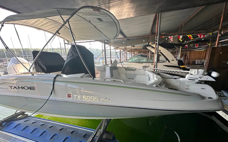Slide: The Image of 2022 Tahoe 2150 CC boat docked under a canopy. - 8