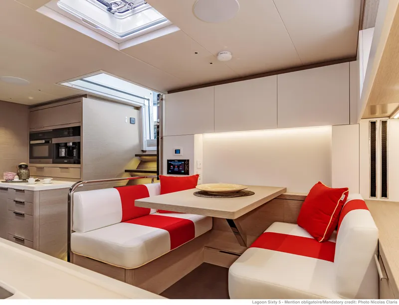 Slide: The Image of Modern interior of 2025 Lagoon Sixty5 yacht with stylish dining area and red accents. - 12