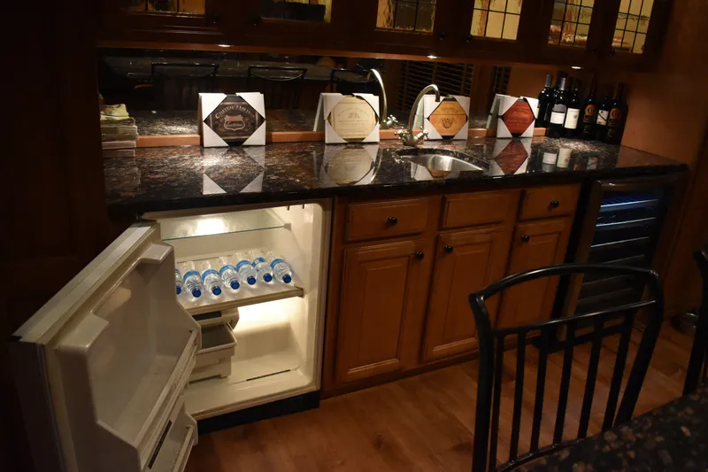 Slide: The Image of 2006 Sumerset Double Dippin houseboat kitchen with open fridge, granite countertops, and wine bottles. - 16