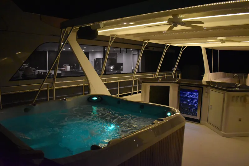 Slide: The Image of Luxurious 2006 Sumerset Double Dippin houseboat with illuminated hot tub and outdoor kitchen at night. - 24