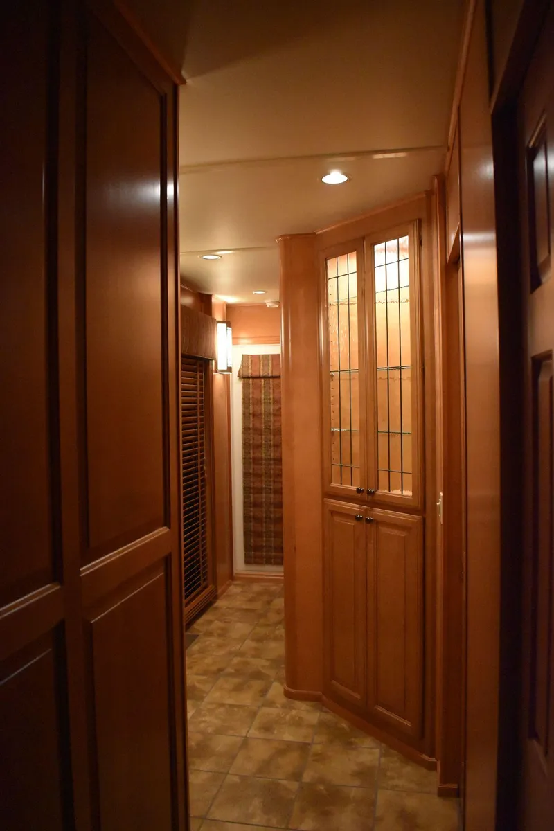 Slide: The Image of 2006 Sumerset Double Dippin houseboat interior hallway with wooden cabinets and tiled floor. - 36