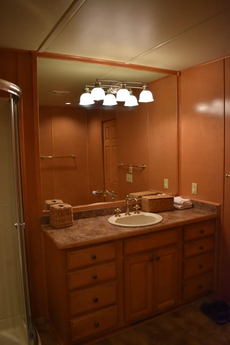 Slide: The Image of Bathroom vanity in 2006 Sumerset Double Dippin houseboat with wooden cabinets and large mirror. - 48