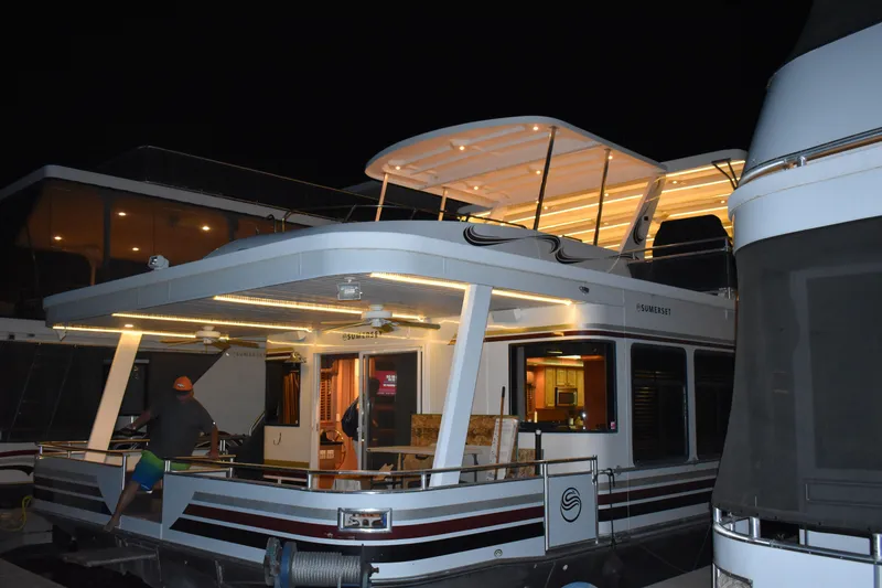 Slide: The Image of 2006 Sumerset Double Dippin houseboat docked at night with illuminated deck. - 5