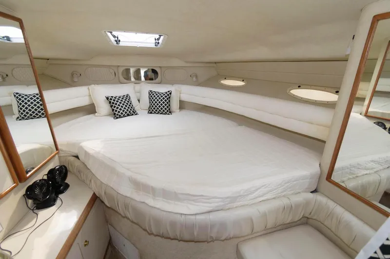 Slide: The Image of 1997 Sea Ray 330 Sundancer cabin with bed and pillows. - 11