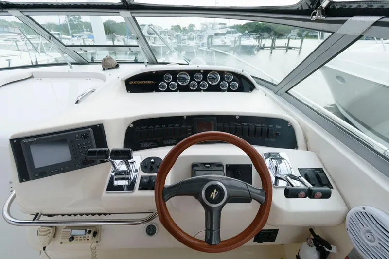 Slide: The Image of 1997 Sea Ray 330 Sundancer helm with steering wheel, gauges, and navigation equipment. - 5