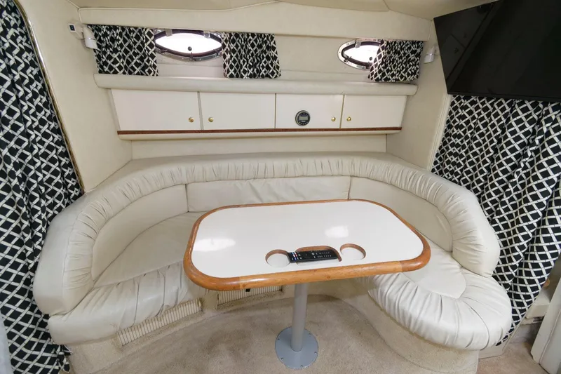 Slide: The Image of 1997 Sea Ray 330 Sundancer cabin interior with curved seating and table. - 8