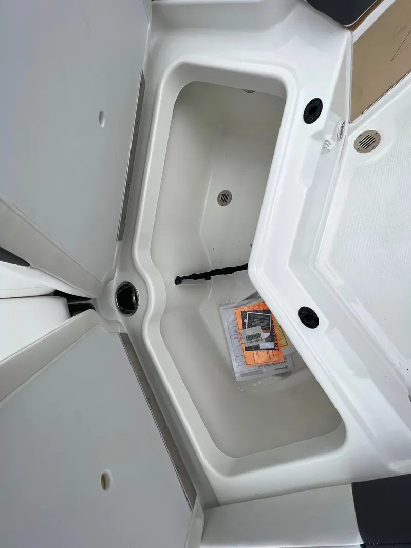 Slide: The Image of 2024 Tahoe 210 S boat storage compartment with manual. - 10