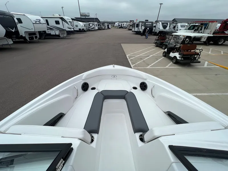 Slide: The Image of 2024 Tahoe 210 S boat interior at a dealership with RVs in the background. - 17