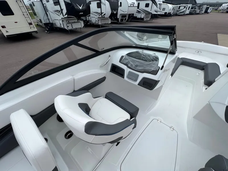 Slide: The Image of 2024 Tahoe 210 S boat interior with white and gray seating, windshield, and dashboard. - 5