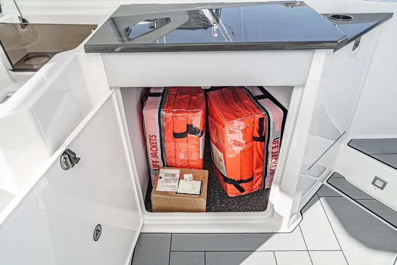 Slide: The Image of Storage compartment on 2024 Aviara AV 32 boat with life jackets and a box. - 25