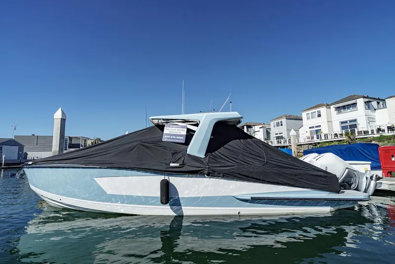 Slide: The Image of 2024 Aviara AV 32 boat docked with a protective cover in a marina. - 49
