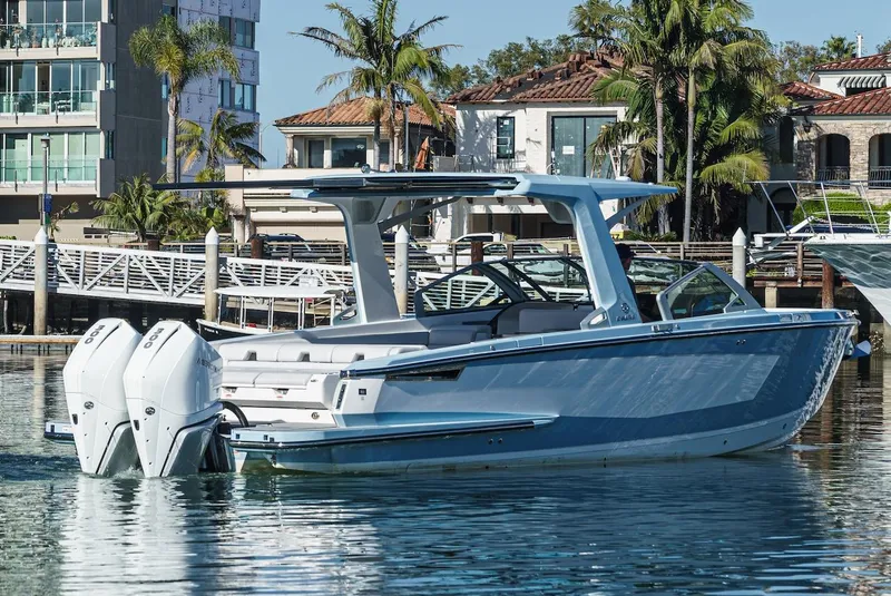 Slide: The Image of 2024 Aviara AV 32 luxury boat docked in a marina with waterfront homes. - 5