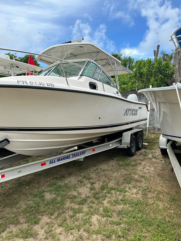 Slide: The Image of 2012 Pursuit 255 boat on trailer, parked outdoors under a blue sky. - 10