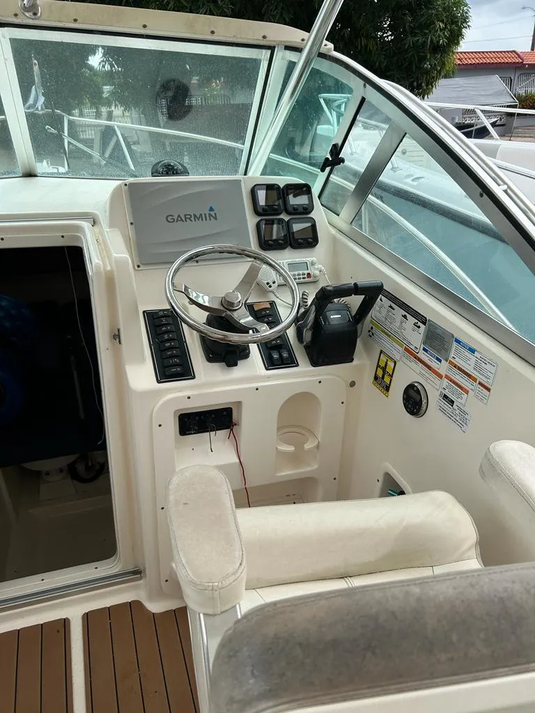 Slide: The Image of 2012 Pursuit 255 boat cockpit with Garmin navigation system and steering wheel. - 2