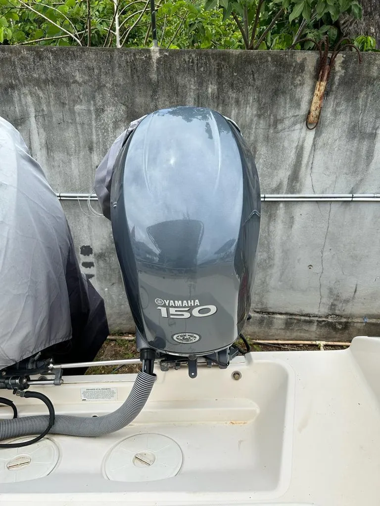 Slide: The Image of Yamaha 150 outboard motor on a 2012 Pursuit 255 boat, parked near a concrete wall. - 9