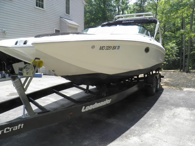 The Image of 2006 MasterCraft 280 SST boat on Loadmaster trailer in driveway. - 0