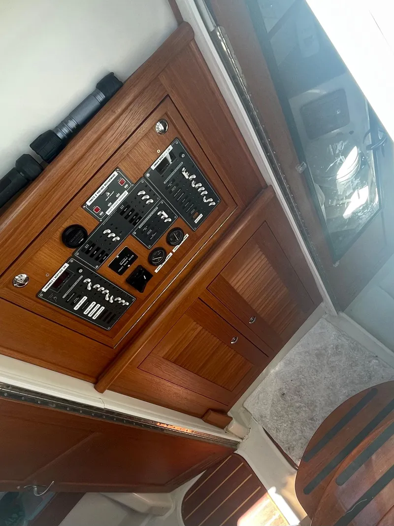 Slide: The Image of 2004 Glacier Bay Ocean Runner 3470 interior with wooden cabinetry and control panel. - 15