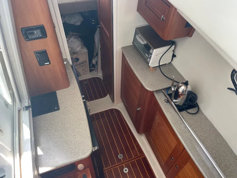 Slide: The Image of 2004 Glacier Bay Ocean Runner 3470 interior with wood cabinetry and kitchen appliances. - 32