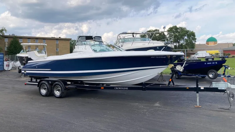 Slide: The Image of 2001 Chris-Craft Launch 25 boat on a trailer in a parking lot. - 1