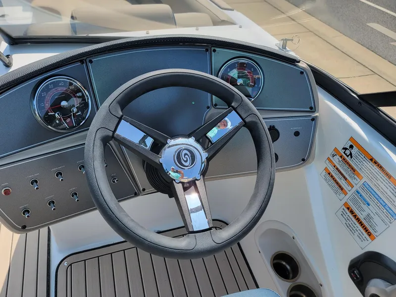 Slide: The Image of 2024 Hurricane SunDeck 217 OB boat dashboard with steering wheel and gauges. - 13