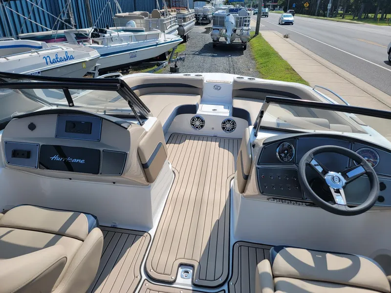 Slide: The Image of 2024 Hurricane SunDeck 217 OB boat interior with beige seating and modern dashboard. - 22