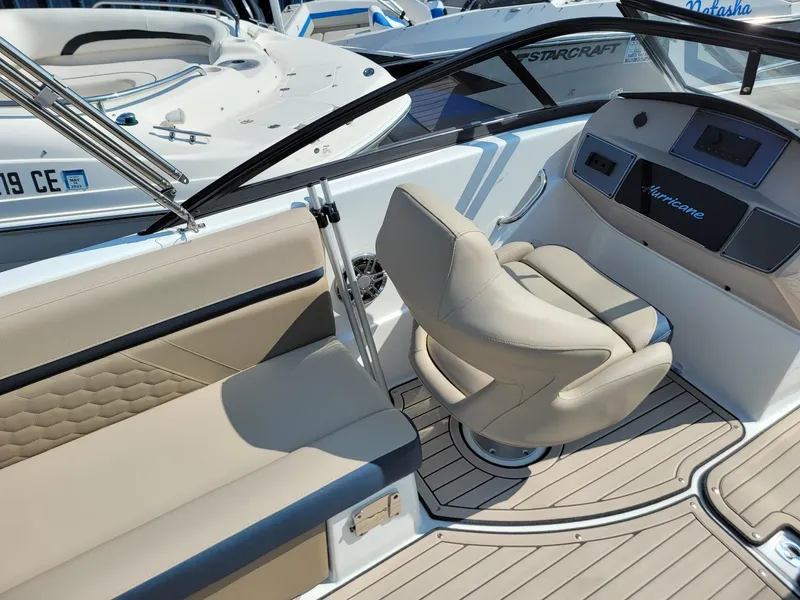 Slide: The Image of 2024 Hurricane SunDeck 217 OB boat interior with beige seating and modern dashboard. - 23