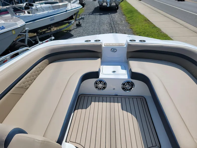 Slide: The Image of 2024 Hurricane SunDeck 217 OB boat interior with beige seating and speakers. - 25