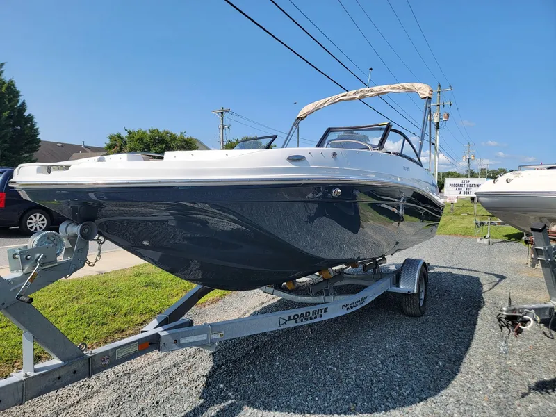 Slide: The Image of 2024 Hurricane SunDeck 217 OB boat on a trailer in a parking lot. - 4