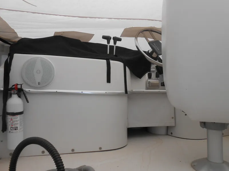 Slide: The Image of 1989 Chris-Craft Amerosport 320 cockpit with steering wheel, controls, and fire extinguisher. - 12