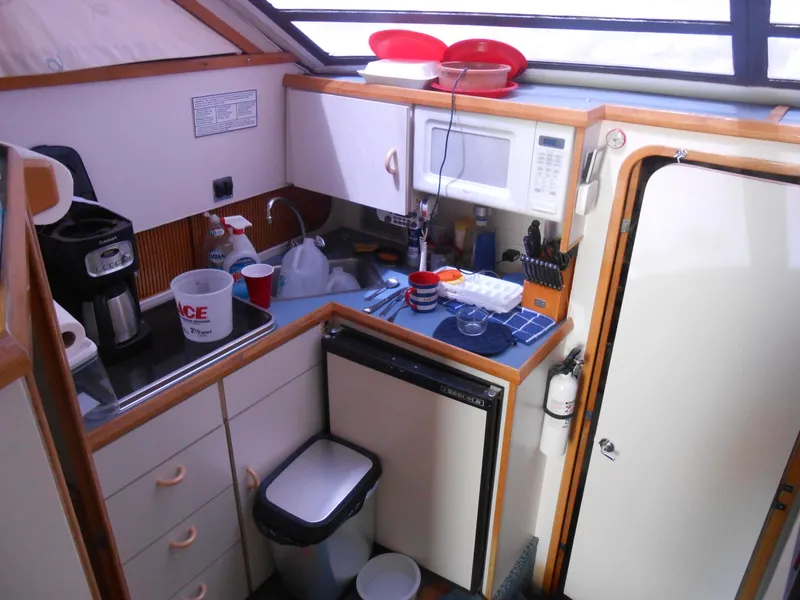 Slide: The Image of 1989 Chris-Craft Amerosport 320 yacht kitchen with microwave, sink, and storage cabinets. - 13