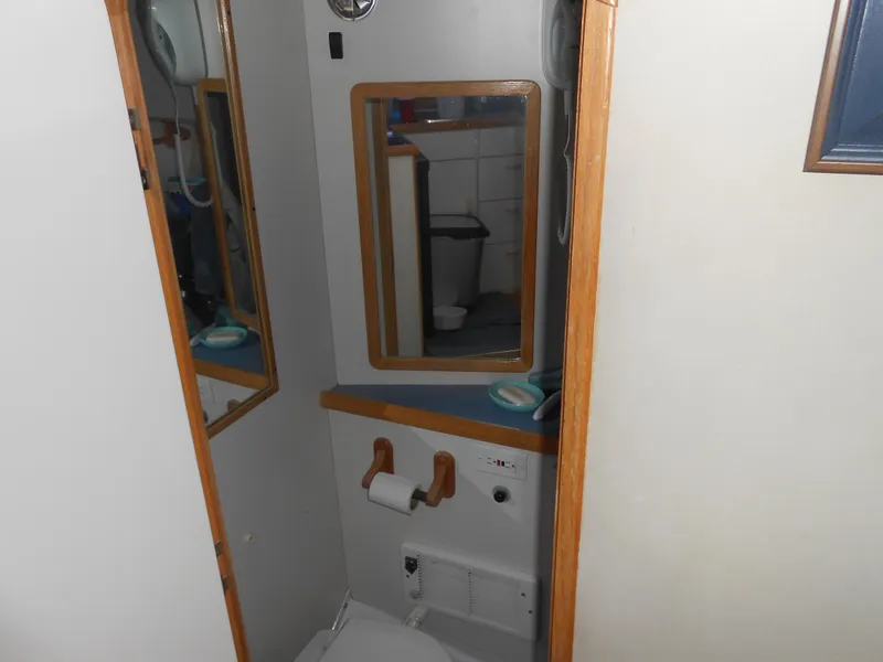 Slide: The Image of 1989 Chris-Craft Amerosport 320 bathroom with mirror, toilet, and wooden accents. - 17