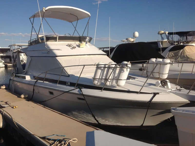 Slide: The Image of 1989 Chris-Craft Amerosport 320 docked at marina, featuring sleek design and spacious deck. - 3