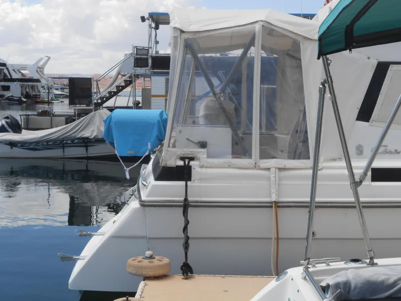 Slide: The Image of 1989 Chris-Craft Amerosport 320 docked at marina, featuring covered cockpit and nearby boats. - 4