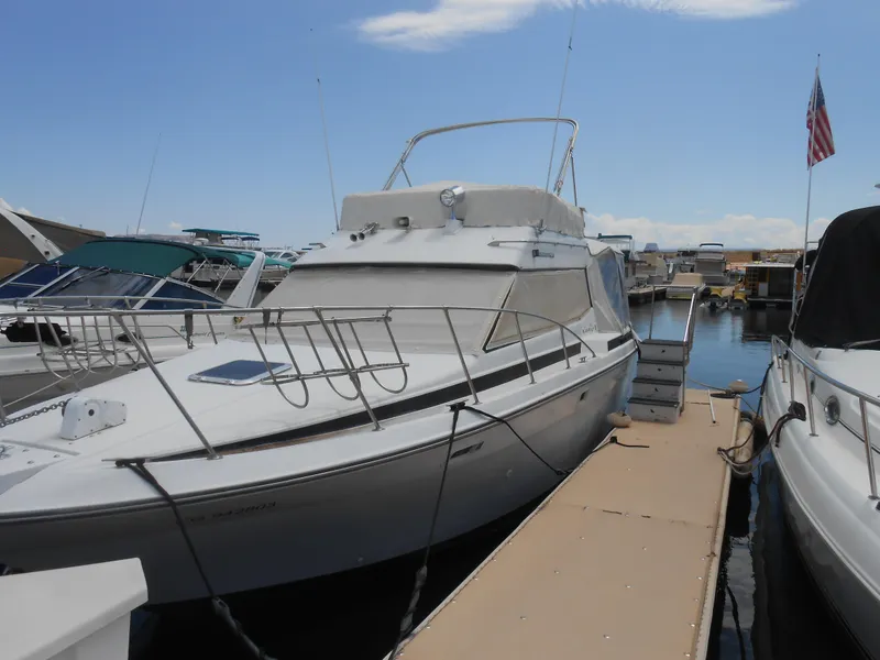 Slide: The Image of 1989 Chris-Craft Amerosport 320 docked at marina under clear sky. - 6