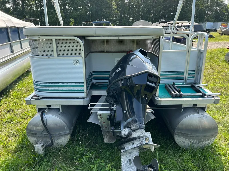 Slide: The Image of 1994 Sylvan Advantage 20 pontoon boat with outboard motor on grass. - 3