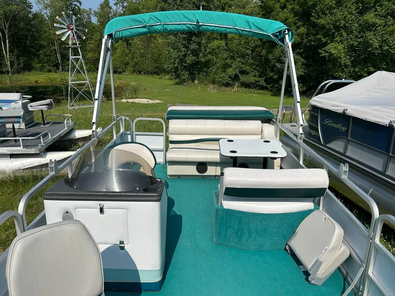 Slide: The Image of 1994 Sylvan Advantage 20 pontoon boat with green canopy and seating. - 4