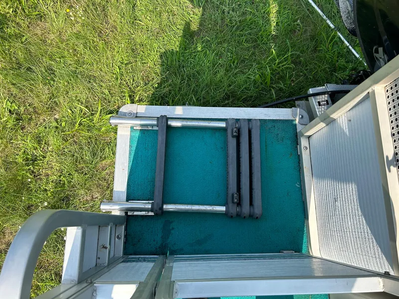 Slide: The Image of 1994 Sylvan Advantage 20 boat ladder on green grass. - 8