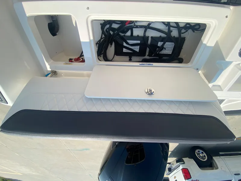 Slide: The Image of 2024 Bayliner Trophy 20 CC boat with open storage compartment and cushioned seating. - 9